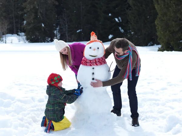 Família fazendo boneco de neve